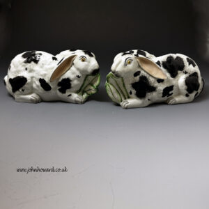 Pair of Staffordshire pottery crouching rabbits eating leaves mid 19th century